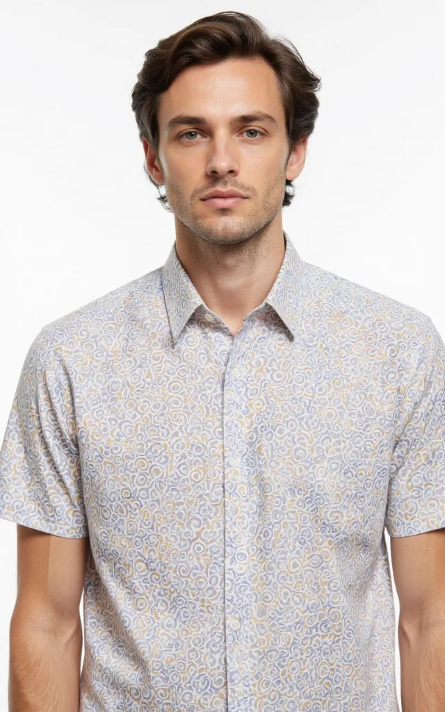 A French model wearing a Circular pattern   printed shirt, against a white background, in a front   facing bust portrait